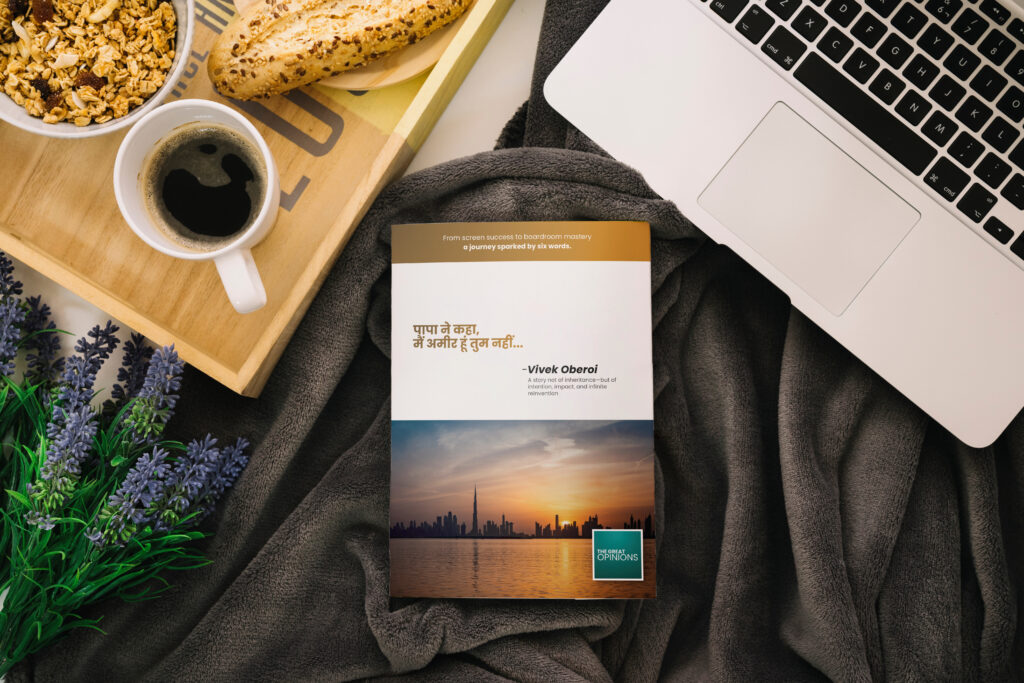 Book cover with Vivek Oberoi quote: “पापा ने कहा, मैं अमीर हूं तुम नहीं…” placed on a cozy blanket beside coffee, croissant, and laptop